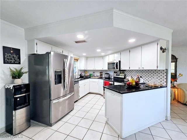 kitchen with stainless steel appliances, tasteful backsplash, and white cabinets