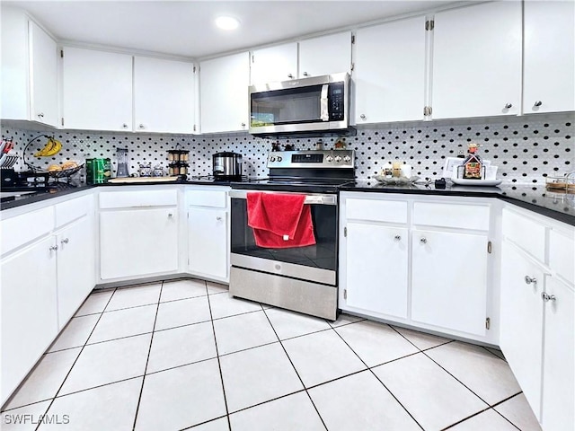 kitchen with stainless steel appliances, white cabinetry, and light tile patterned floors