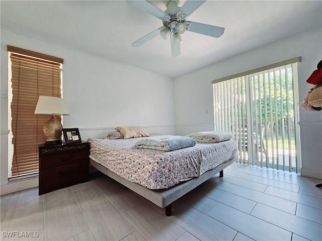 bedroom featuring ceiling fan, access to exterior, and multiple windows