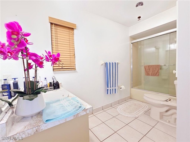 full bathroom with toilet, vanity, bath / shower combo with glass door, and tile patterned flooring