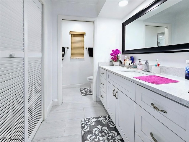 bathroom featuring vanity, toilet, and tile patterned flooring