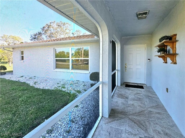 property entrance with a lawn