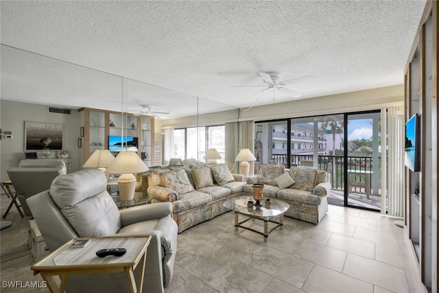 tiled living room with a textured ceiling and ceiling fan