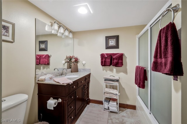 full bathroom featuring vanity, bath / shower combo with glass door, and toilet