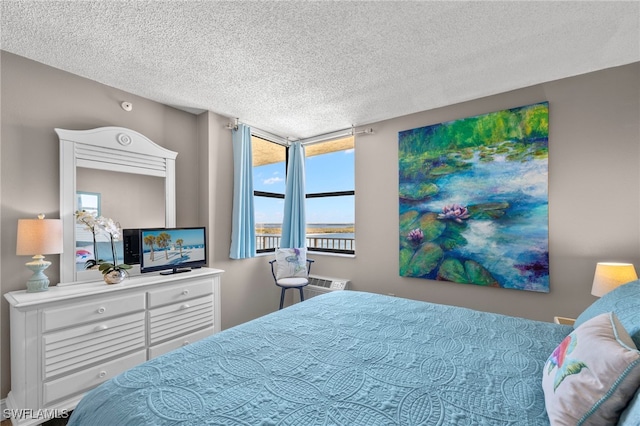 bedroom featuring a wall mounted AC and a textured ceiling