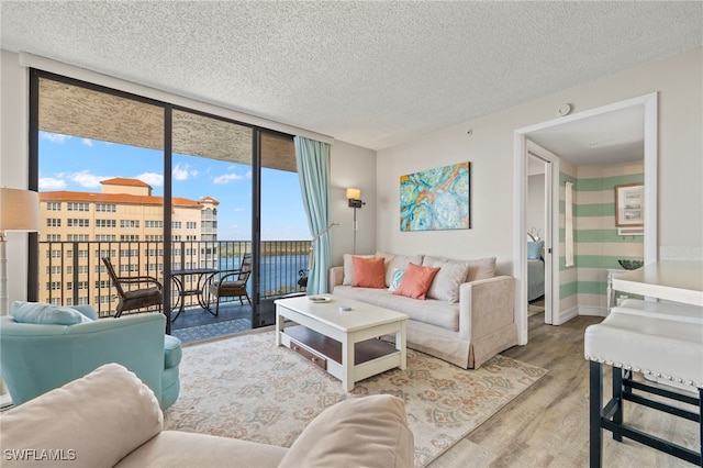 living room with floor to ceiling windows, wood-type flooring, and a textured ceiling