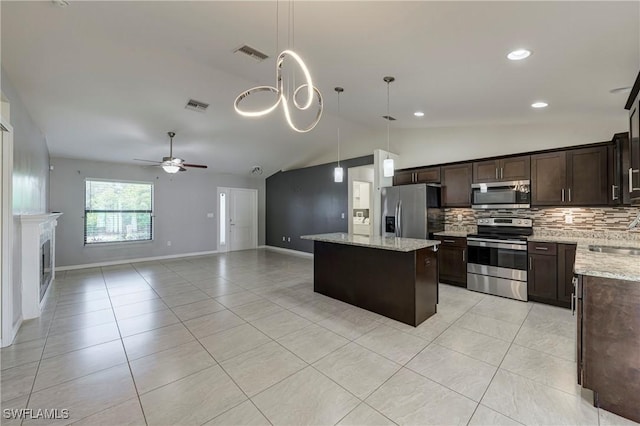 kitchen featuring stainless steel appliances, light stone countertops, a kitchen island, and pendant lighting