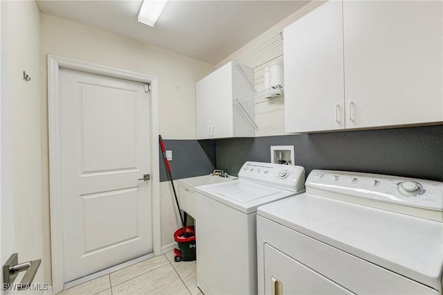 laundry area featuring cabinets, washing machine and dryer, sink, and light tile patterned flooring