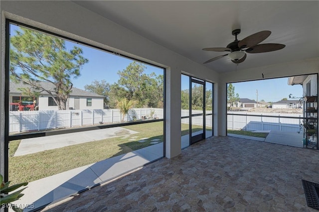 unfurnished sunroom with ceiling fan