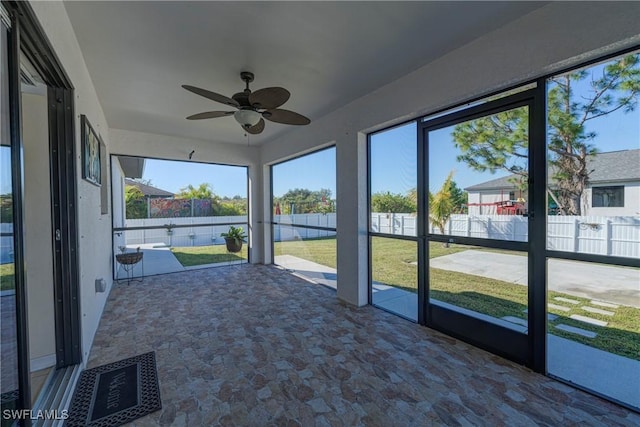 unfurnished sunroom with ceiling fan and a healthy amount of sunlight