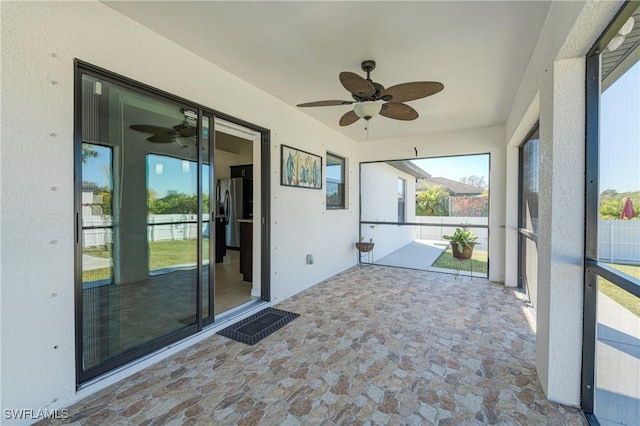 unfurnished sunroom featuring ceiling fan