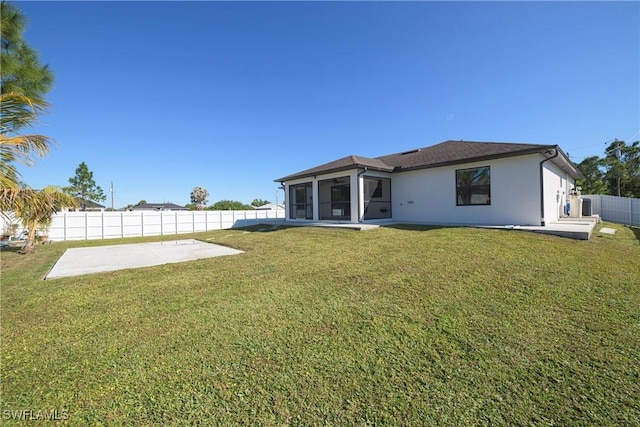 back of house with a patio area, a sunroom, central air condition unit, and a lawn