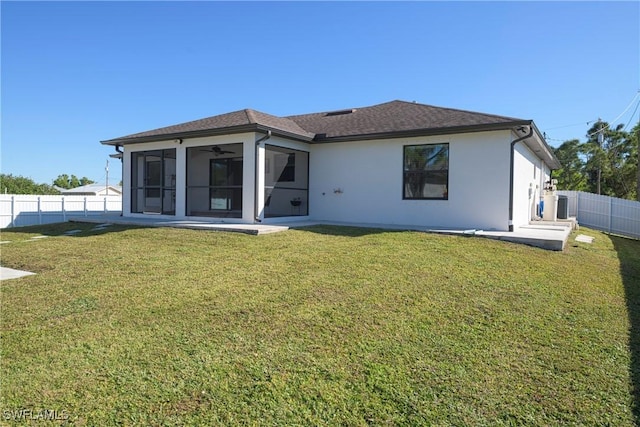 back of house with a sunroom, central air condition unit, and a lawn