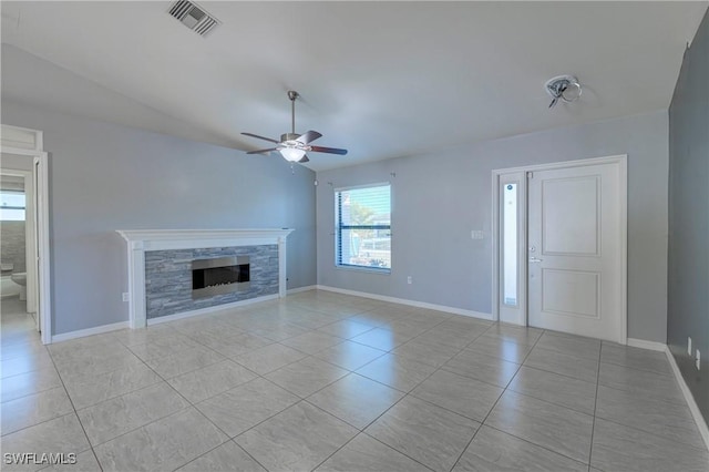 unfurnished living room featuring ceiling fan, a fireplace, and light tile patterned floors