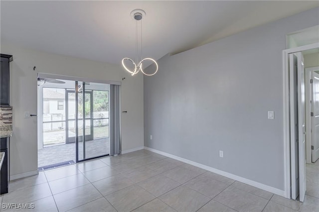 empty room featuring ceiling fan with notable chandelier and light tile patterned floors