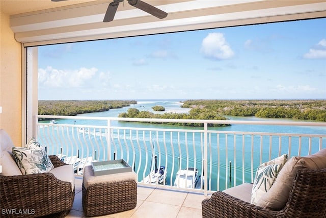 balcony with a water view and ceiling fan