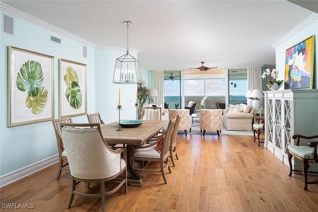 dining space featuring light wood-style flooring, a ceiling fan, ornamental molding, and visible vents