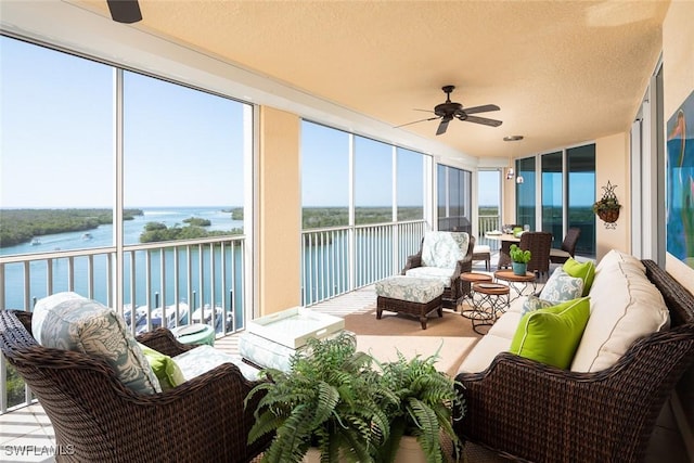 sunroom featuring a water view and a textured ceiling