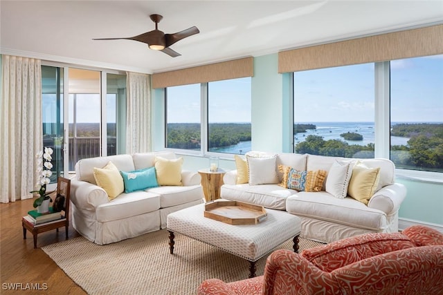 living room featuring a water view, a ceiling fan, and wood finished floors