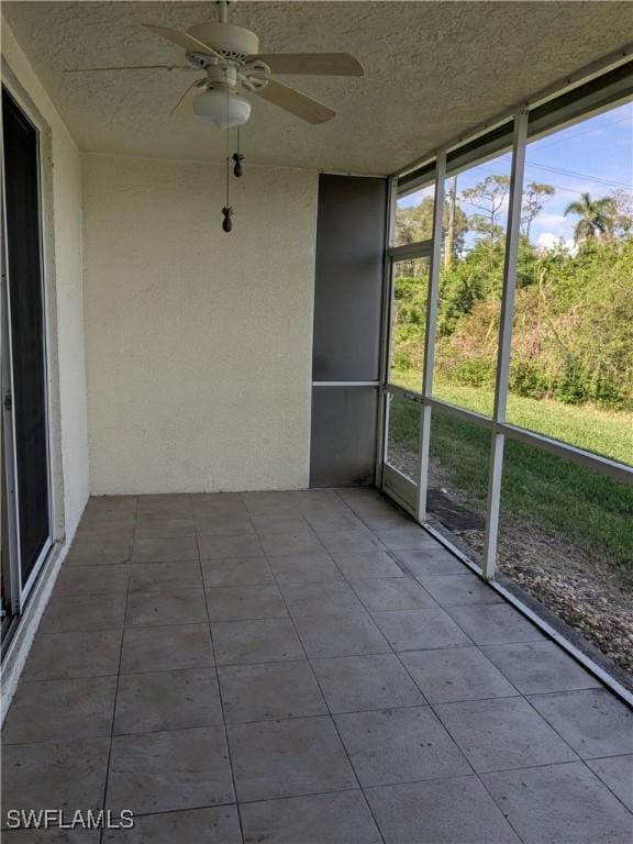 unfurnished sunroom with a wealth of natural light and ceiling fan