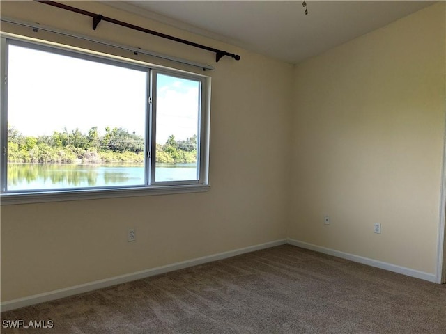 carpeted spare room with a water view