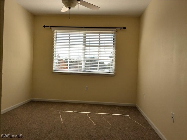 unfurnished room with dark colored carpet and ceiling fan