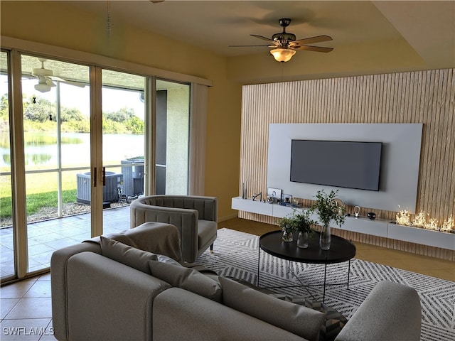 tiled living room featuring a water view, a wealth of natural light, and ceiling fan