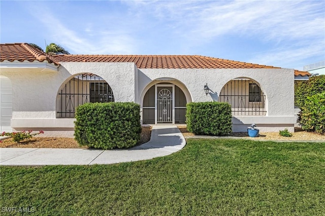 mediterranean / spanish home featuring a front lawn