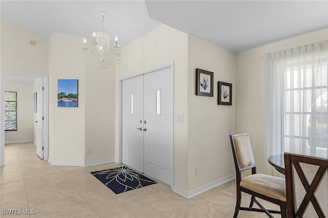 tiled entrance foyer with an inviting chandelier and plenty of natural light