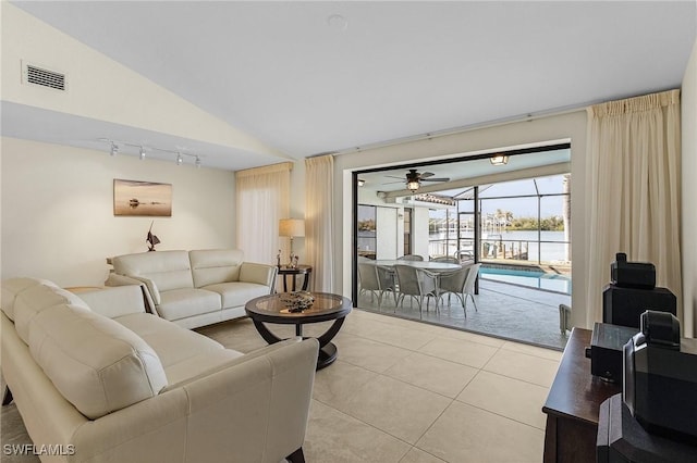 living room with light tile patterned flooring, vaulted ceiling, ceiling fan, and rail lighting