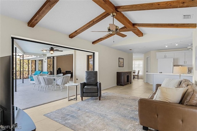 tiled living room with ceiling fan and vaulted ceiling with beams