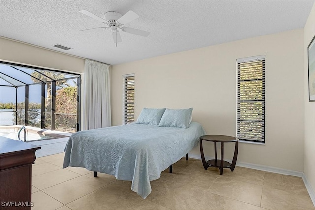 tiled bedroom featuring access to exterior, a textured ceiling, and ceiling fan