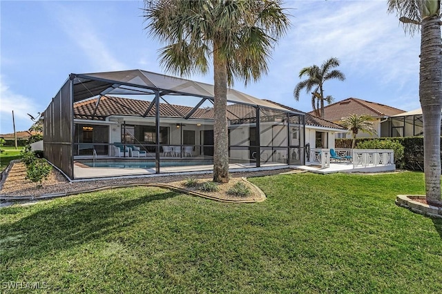 rear view of house featuring a lawn, glass enclosure, and a patio area