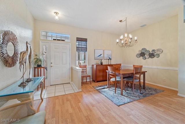 dining room featuring light hardwood / wood-style flooring and a chandelier