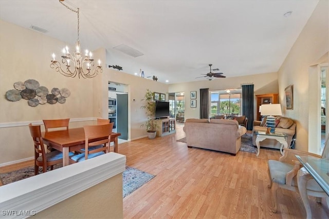 living room featuring ceiling fan with notable chandelier and light hardwood / wood-style flooring