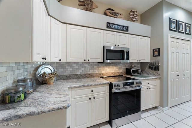 kitchen with stainless steel appliances, decorative backsplash, and white cabinets