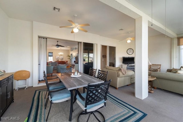 dining room featuring ceiling fan and dark colored carpet