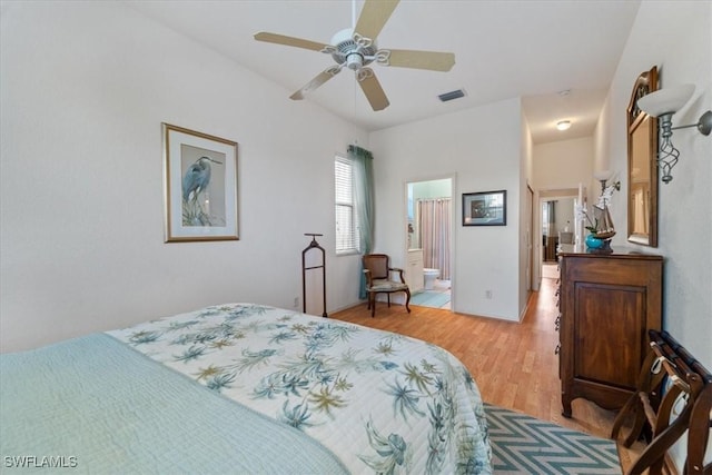 bedroom with ensuite bath, light hardwood / wood-style flooring, and ceiling fan