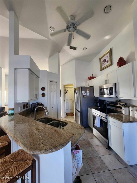 kitchen featuring white cabinetry, sink, a kitchen bar, kitchen peninsula, and stainless steel appliances