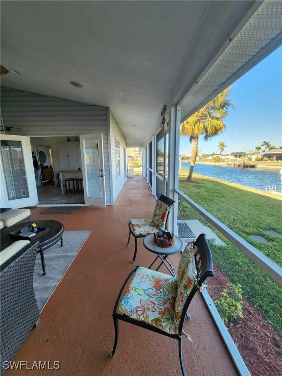 sunroom featuring vaulted ceiling and a water view