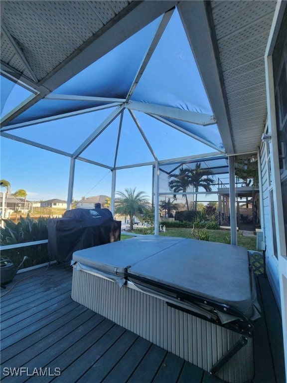 deck featuring a lanai, area for grilling, and a covered hot tub