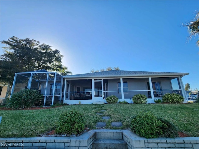 view of front of house with a sunroom and a front yard