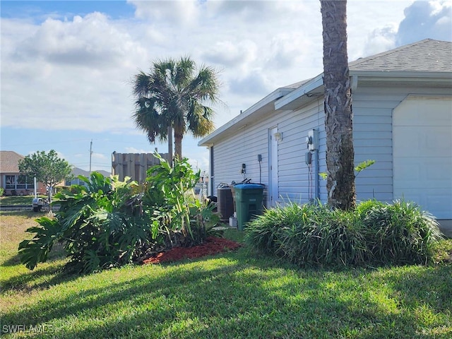 view of side of home featuring a garage and a lawn