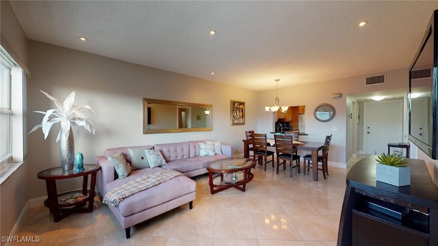 living room featuring a chandelier, a textured ceiling, and light tile patterned flooring