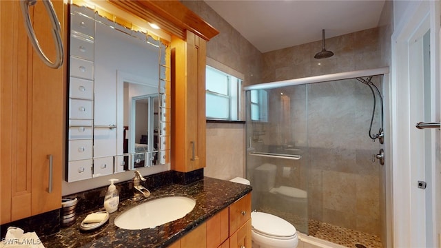 bathroom with walk in shower, vanity, and toilet