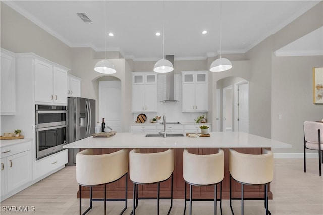 kitchen with pendant lighting, sink, a center island with sink, and white cabinets