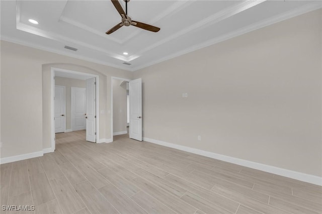 unfurnished bedroom featuring ornamental molding, light hardwood / wood-style floors, a raised ceiling, and ceiling fan