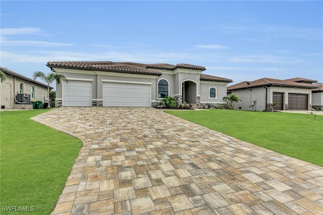 mediterranean / spanish-style house featuring a garage, central AC, and a front yard