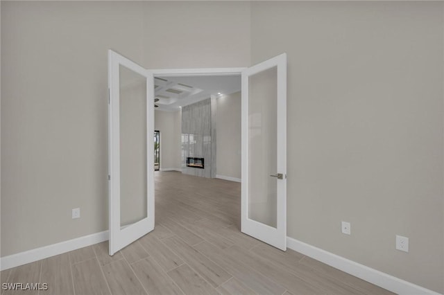 unfurnished room featuring a high end fireplace and french doors