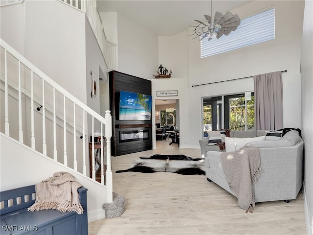 living room featuring a high ceiling and light hardwood / wood-style floors